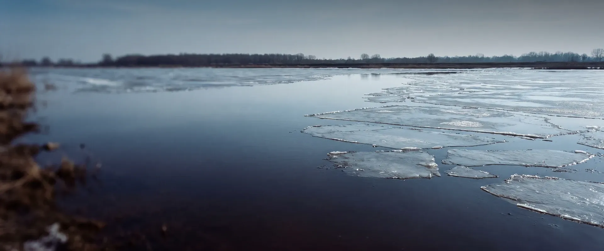 Loskomen van een narcist: ijsschotsen die in de dooi loskomen en wegdrijven op een brede rivier onder een donkere lucht