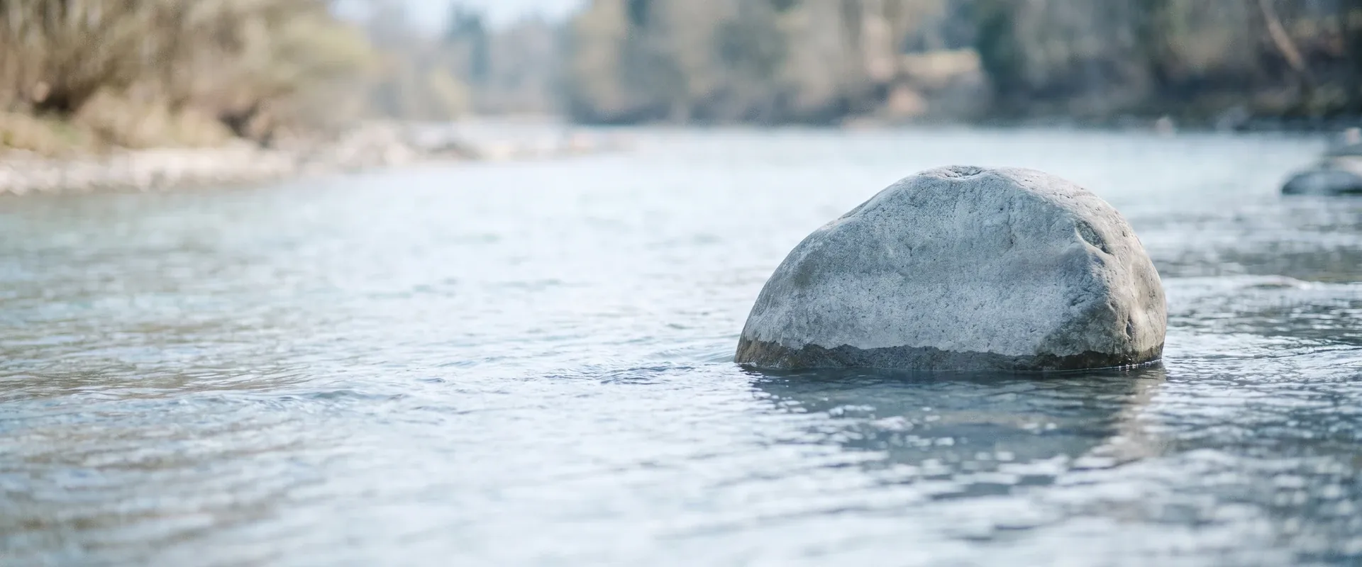 Omgaan met een narcist: een grote steen in een ondiepe rivier, het water stroomt er rustig omheen